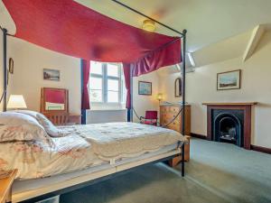 a bedroom with a canopy bed and a fireplace at 2 Bed in Lochgilphead oc-ag577 in Kilmartin