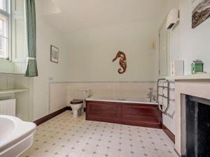 a bathroom with a tub and a toilet and a sink at 2 Bed in Lochgilphead oc-ag577 in Kilmartin