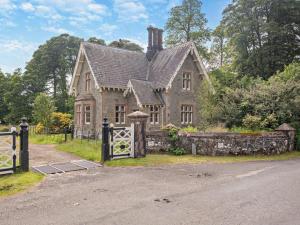 an old house with a stone fence and a gate at 2 Bed in Lochgilphead oc-ag577 in Kilmartin