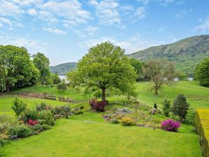 a garden with flowers and a tree in a field at 2 Bed in Ulverston oc-94926 in Lakeside
