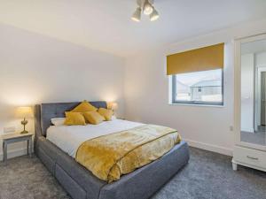 a bedroom with a bed with yellow pillows and a window at 3 Bed in Kinlochleven oc-87130 in Kinlochleven