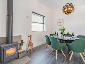 a dining room with a fireplace and a table with green chairs at 3 Bed in Kinlochleven oc-87130 in Kinlochleven +11 photos