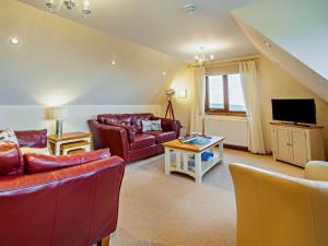 a living room with red couches and a tv at 3 Bed in Isle Of Arran oc-ca099 in Sliddery