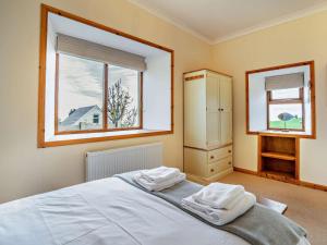a bedroom with a bed with two towels on it at 3 Bed in Isle Of Arran oc-ca099 in Sliddery