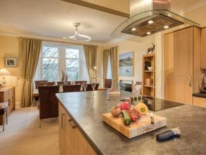 a kitchen and living room with a table with fruits on a cutting board at 4 Bed in Isle Of Skye oc-ca363 in Glendale