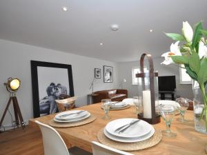 a dining room table with white plates and flowers on it at 3 Bed in Tetbury oc-44955 in Tetbury +10 photos