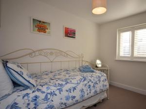 a bedroom with a blue and white bed and a window at 3 Bed in Tetbury oc-44955 in Tetbury
