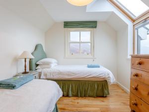 two beds in a room with a window at 3 Bed in Achnasheen oc-ca120 in Inveralligin