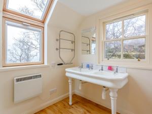 a white bathroom with a sink and two windows at 3 Bed in Achnasheen oc-ca120 in Inveralligin +27 photos