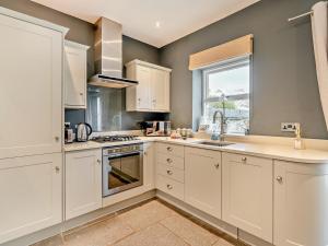 a kitchen with white cabinets and a sink and a window at 2 Bed in Grange-over-sands oc-83546 in Cartmel +5 photos