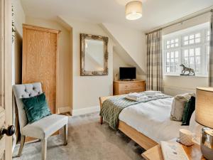 a bedroom with a bed and a chair and a mirror at 2 Bed in Grange-over-sands oc-83546 in Cartmel
