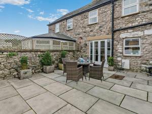a patio with chairs and a table in front of a building at 2 Bed in Grange-over-sands oc-83546 in Cartmel