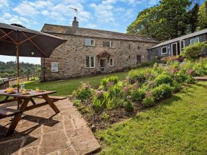 a picnic table with an umbrella in front of a building at 3 Bed in Penrith oc-94982 in Pooley Bridge