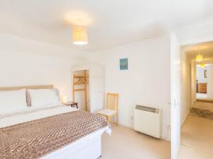 a white bedroom with a bed and a chair at 2 Bed in Gairloch oc-ca137 in Big Sand