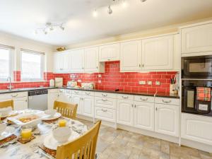 a kitchen with white cabinets and a table with chairs at 3 Bed in Isle Of Skye oc-81181 in Luib