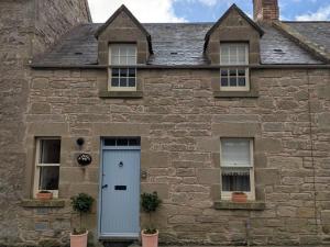 an old stone house with a white door and windows at 1 Bed in Duns oc-95832 in Duns