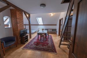 a living room with a table and a tv at Penzion Novopacké Sklepy in Nová Paka
