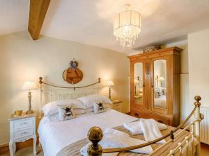 a bedroom with a large white bed and a chandelier at 1 Bed in Grange-over-sands oc-89364 in Cartmel