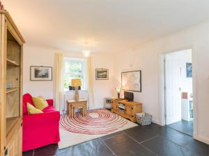 a living room with a red couch and a table at 1 Bed in Brechin oc-ca217 in Edzell
