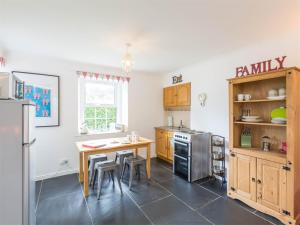 a kitchen with a table and a refrigerator and a table and chairs at 1 Bed in Brechin oc-ca217 in Edzell