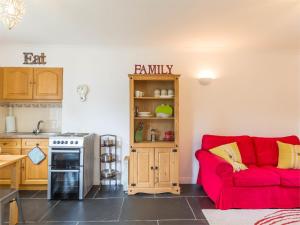 a living room with a red couch in a kitchen at 1 Bed in Brechin oc-ca217 in Edzell +9 photos
