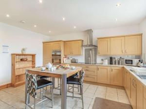 a kitchen with wooden cabinets and a wooden table with chairs at 4 Bed in Ballindalloch oc-46162 in Tomintoul +16 photos