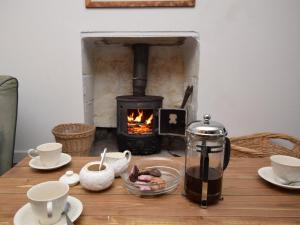 a wooden table with a stove in a fireplace at 3 Bed in Isle Of North Uist oc-77239 in Sollas