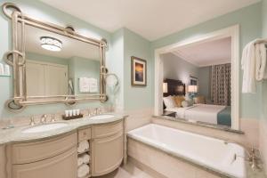 a bathroom with two sinks and a tub and a bed at Henderson Beach Resort in Destin