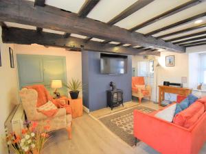 a living room with orange furniture and a television at 2 Bed in Kirkby Thore oc-78744 in Kirkby Thore