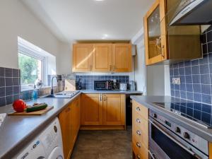 a kitchen with wooden cabinets and a counter top at 2 Bed in Kirkby Thore oc-78744 in Kirkby Thore