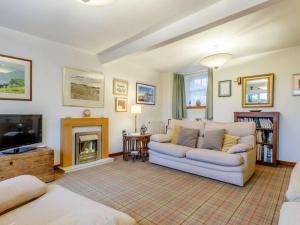 a living room with a couch and a fireplace at 2 Bed in Anstruther oc-ca006 in Crail