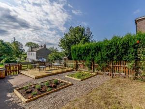 a garden with three raised beds and a fence at 2 Bed in Kirkby Thore oc-78744 in Kirkby Thore