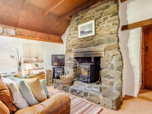 a living room with a large stone fireplace at 1 Bed in Isle Of Skye oc-ca073 in Glendale