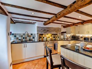 a kitchen with white cabinets and a table and chairs at 3 Bed in Grange-over-sands oc-95100 in Cark