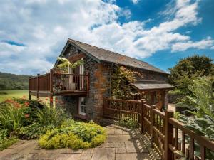 a brick house with a balcony and a wooden fence at 1 Bed in Coniston oc-lcc37 in High Nibthwaite