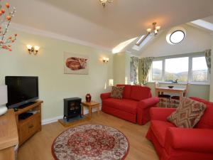 a living room with red couches and a tv at 1 Bed in Telford oc-73319 in Buildwas