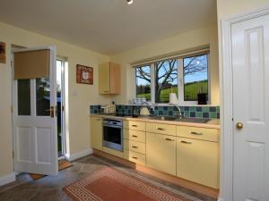 a kitchen with yellow cabinets and a sink and a window at 1 Bed in Telford oc-73319 in Buildwas +13 photos