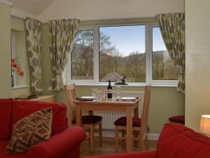 a dining room with a table and two windows at 1 Bed in Telford oc-73319 in Buildwas