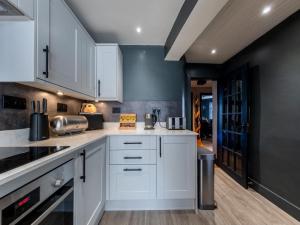 a kitchen with white cabinets and a black wall at 3 Bed in Stranraer oc-77308 in Portpatrick