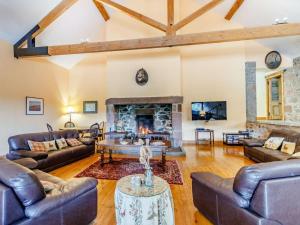 a living room with leather furniture and a fireplace at 8 Bed in Kirriemuir oc-ca261 in Kirriemuir