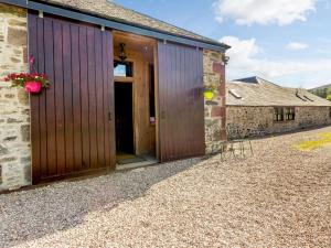 an external view of a barn with wooden doors at 8 Bed in Kirriemuir oc-ca261 in Kirriemuir