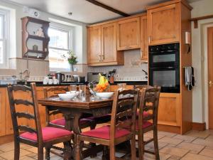 a kitchen with a wooden table and chairs at 3 Bed in Threlkeld oc-sz421 in Threlkeld