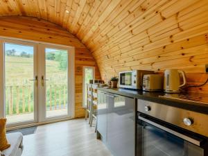 a kitchen with wooden walls and a large window at 1 Bed in Coniston oc-88961 in Coniston