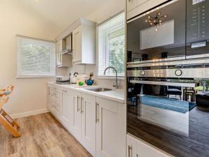 a kitchen with white cabinets and stainless steel appliances at 2 Bed in Swansea oc-91724 in Killay +10 photos