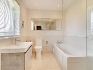 a bathroom with a tub and a toilet and a sink at 2 Bed in Swansea oc-91724 in Killay