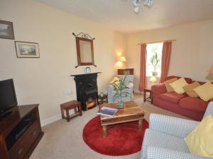 a living room with a red couch and a fireplace at 2 Bed in Fort Augustus oc-in637 in Fort Augustus