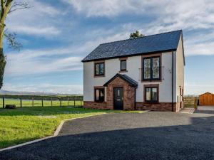 a white house with a black roof at 4 Bed in Penrith oc-89353 in Little Salkeld