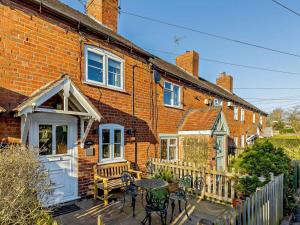 a brick house with a table and chairs on a patio at 2 Bed in Ludlow oc-91422 in Ludlow
