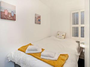 a white bedroom with a bed with towels on it at 2 Bed in Morecambe oc-93719 in Heysham