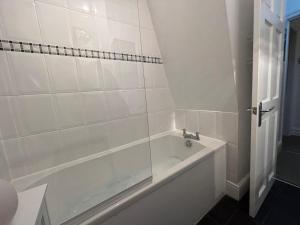 a white bath tub in a white tiled bathroom at 2 Bed in Morecambe oc-93719 in Heysham +11 photos